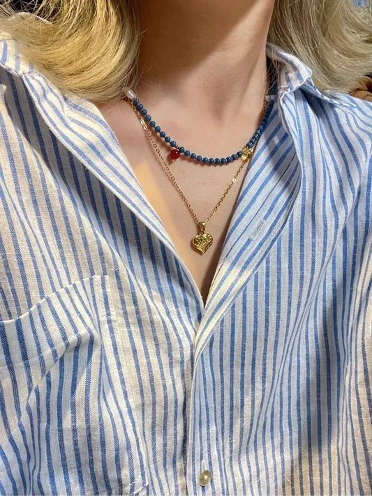 Layering the Blue bead choker with a delicate gold chain necklace for a stylish, bohemian look.