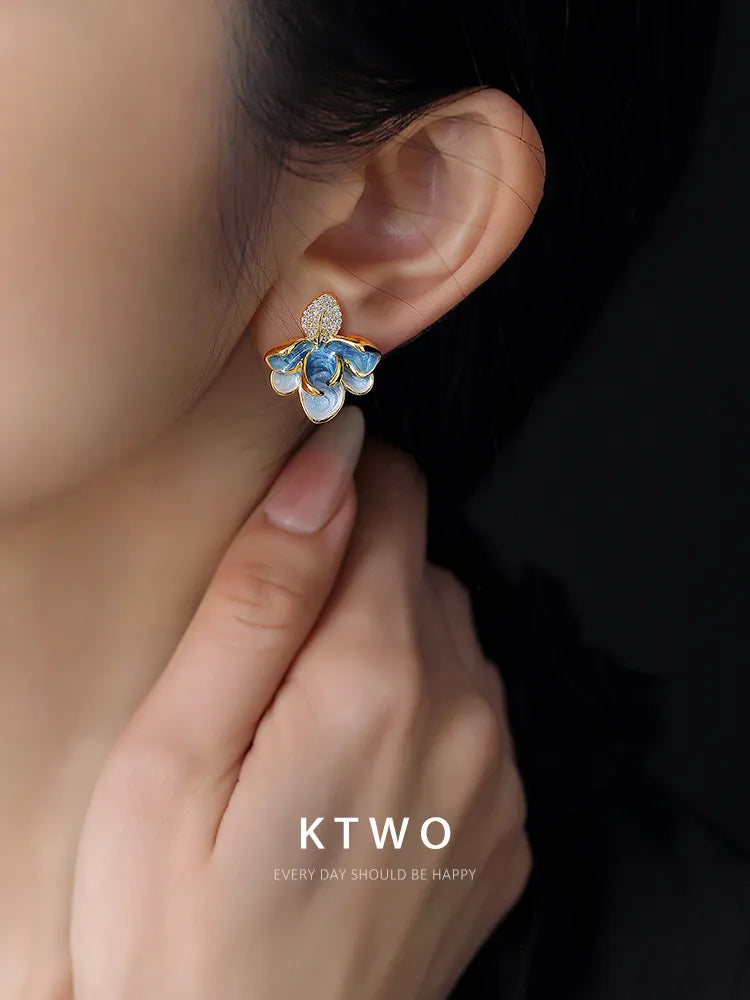 Close-up detail of the unique blue drip glaze enamel on a delicate gold tone leaf.