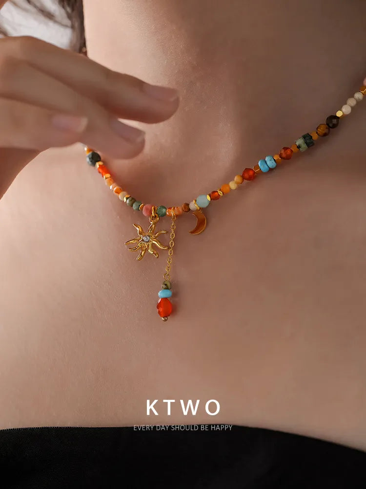 Close-up shot of the model's neckline, focusing on how the beautiful sun and moon pendant hangs gracefully with the beaded tassel.