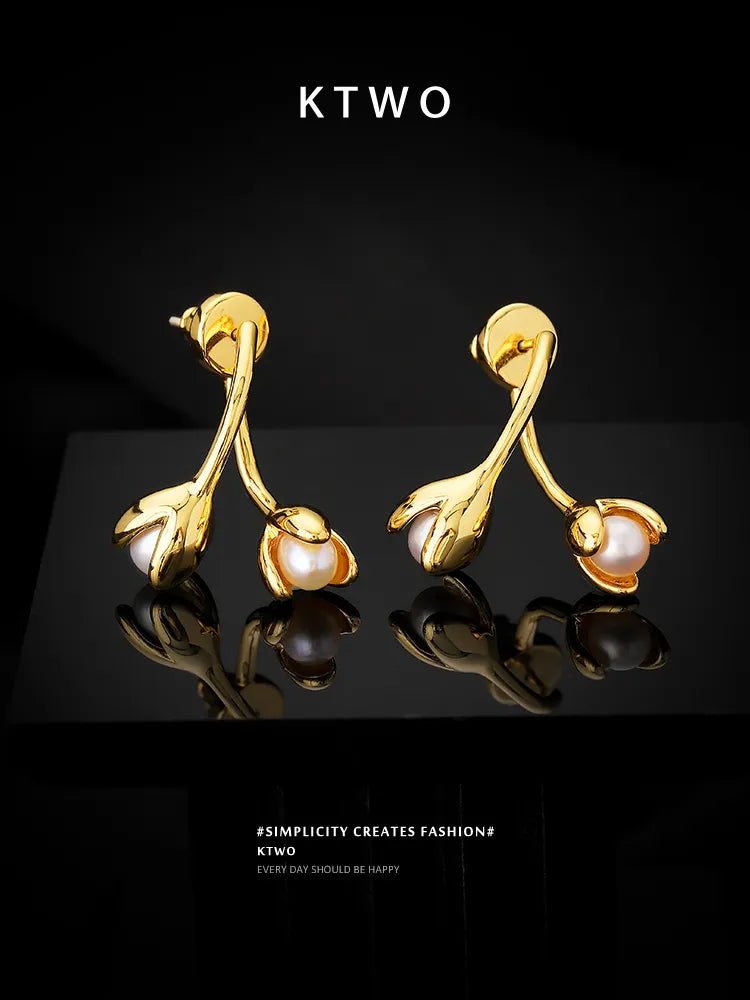 A beautiful flat lay presentation of the golden floral pearl stud earrings