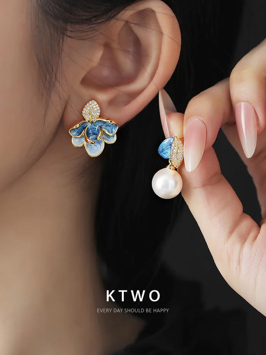 Woman wearing asymmetric artistic enamel and pearl earrings, showcasing a bohemian elegance.