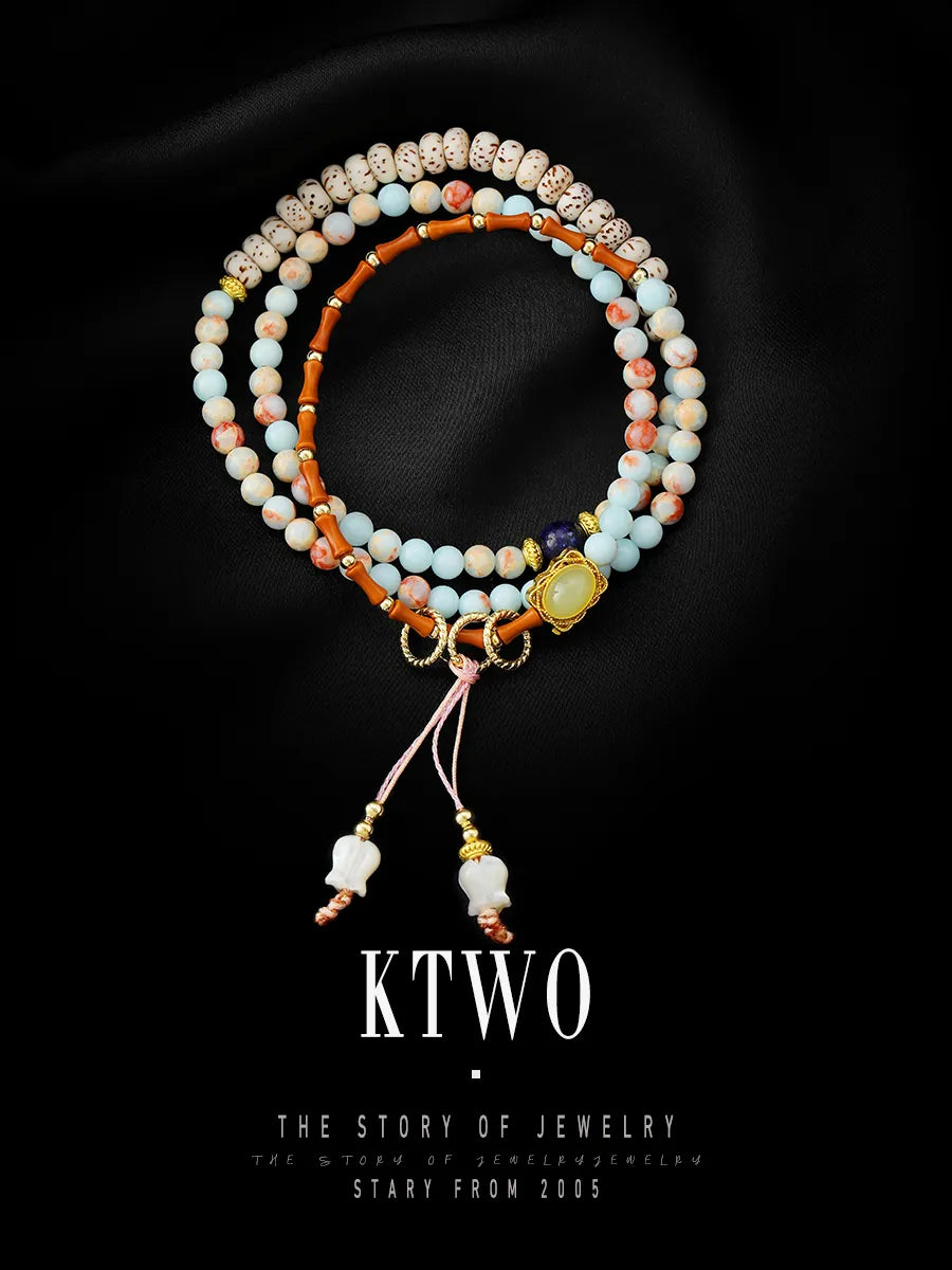 The long convertible bracelet draped elegantly on a black background, emphasizing its length and the beautiful drape of the lapis lazuli and blue beads.