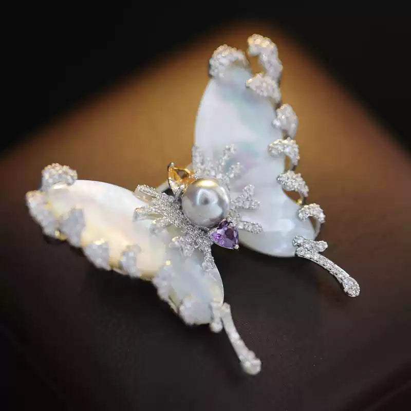 Detail of the micro-pavé zircon setting and the natural texture of the gray pearl on the moth brooch