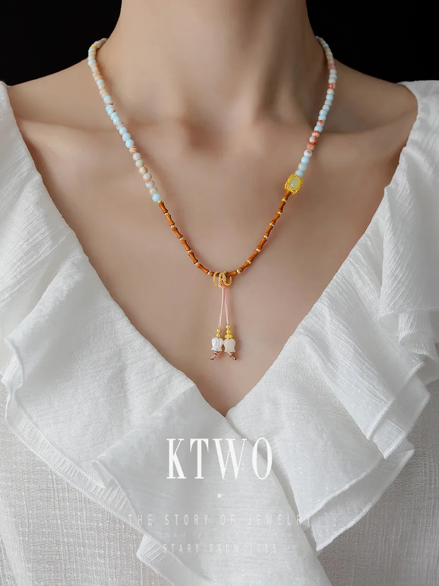 Stylish model wearing the long beaded bracelet as a necklace or choker. This convertible jewelry piece showcases its versatility from wrist to neck.