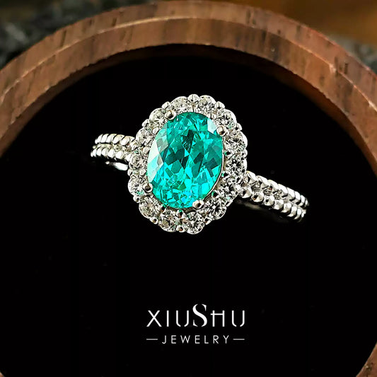 Angled view of the sterling silver Paraiba ring catching the light, showing off its sparkle .