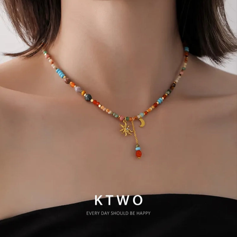 A young girl wearing the colorful sun moon necklace with a casual summer dress, showcasing a free-spirited boho style.