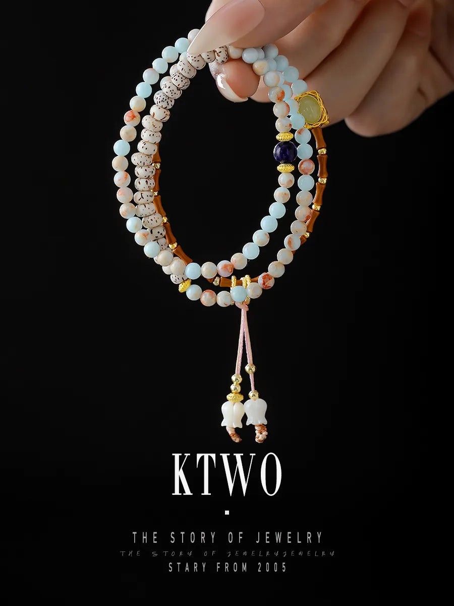 Our signature long bracelet displayed in a three-wrap circle on a black background. This versatile piece can be worn as a layered bracelet or a statement necklace.