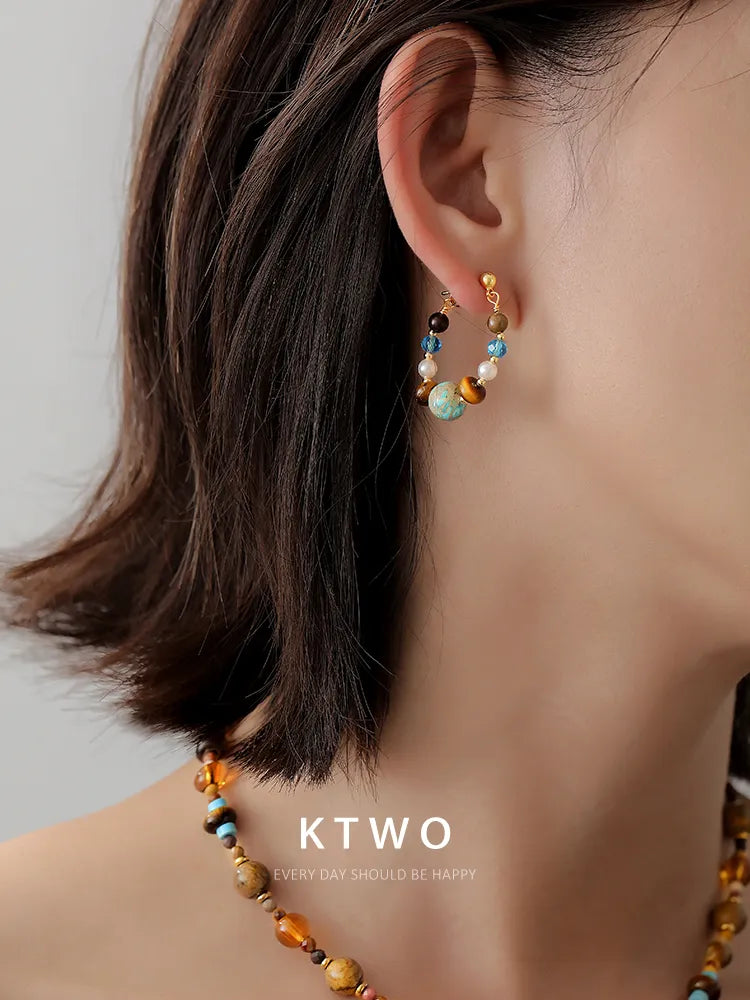 A woman wearing our vintage tiger eye and turquoise drop earrings.