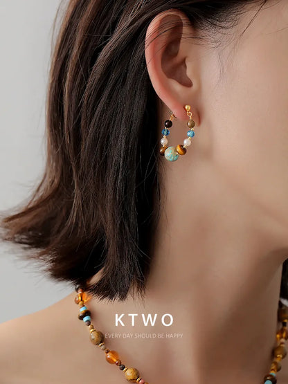A woman wearing our vintage tiger eye and turquoise drop earrings.
