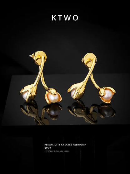 A beautiful flat lay presentation of the golden floral pearl stud earrings