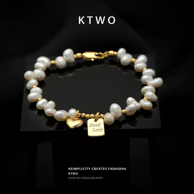 Close-up of the luminous freshwater pearl and gold heart charm