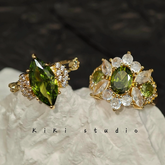 Front view of an elegant olive green vintage adjustable ring on a black background, showcasing its Art Deco design and luxurious color.