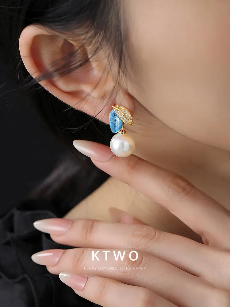 Smooth white fresh water pearl accent on a handmade asymmetric leaf design earring.