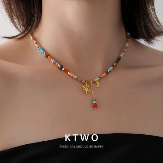 A young girl wearing the colorful sun moon necklace with a casual summer dress, showcasing a free-spirited boho style.